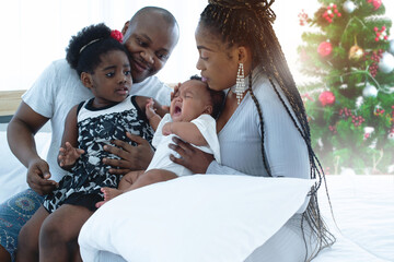 Older sister looked at her sister crying, African mother held the child and tried to calm down her baby, African family