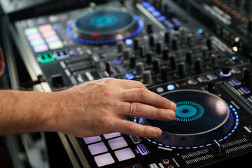 Fototapeta na wymiar DJ playing music with sound mixer controller