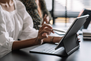 Young business woman meeting to work and using digital tablet with their colleagues in the office.