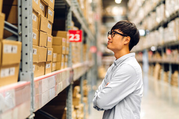 Fototapeta na wymiar Portrait of smiling asian manager worker man standing and order details checking goods and supplies on shelves with goods background in warehouse.logistic and business export
