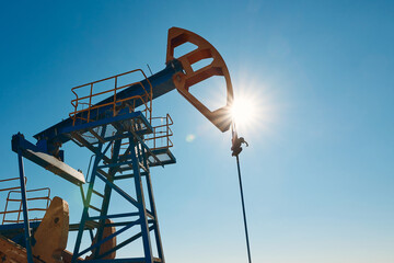 Oil pump are working in the blue sky background. 
World Oil Industry. Western region of...