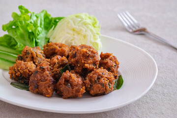 Deep fried spicy minced pork served with vegetable on  plate, Thai food.