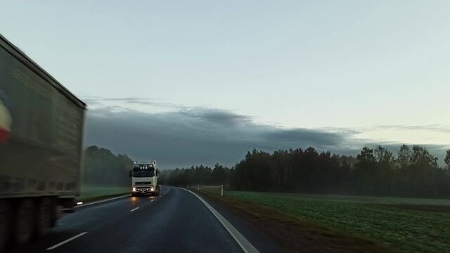 Driving rural countryside road  in the misty early morning. Driver point of view POV. Lithuania Via Baltic Road. Truck drives in other side.