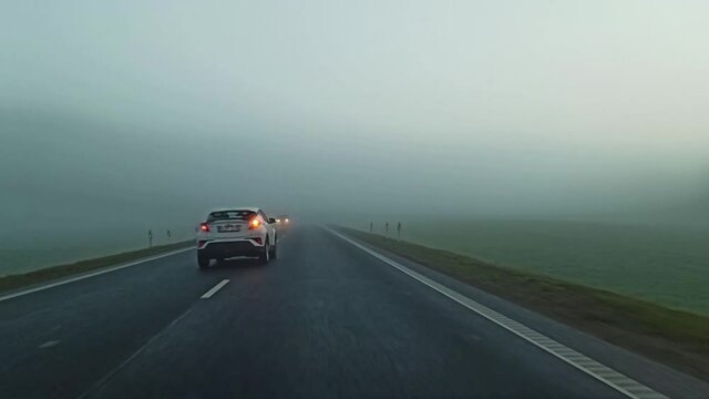 Driving rural countryside road  in the misty early morning. Driver point of view POV. Lithuania Via Baltic Road. Truck drives in other side.