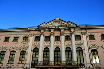 The facade of the house with columns against the blue sky in St. Petersburg. Architecture of St. Petersburg. Russia, St. Petersburg, 20.08.2020. High quality photo