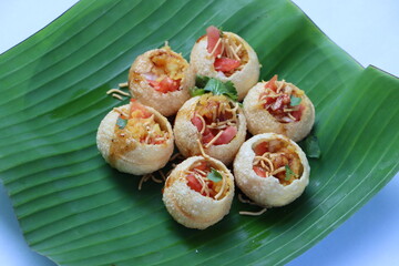 Shev Batata Puri chat, Aloo puri chaat, Indian popular street food, appetizer or snack, served on banana leaf