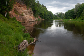 
Latvian nature, with a beautiful river and tree branches, with a green landscape