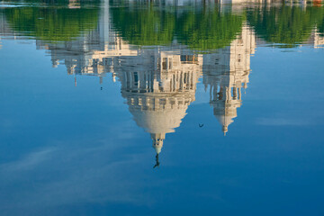 Fototapeta na wymiar Rippled reflection of the Victoria Memorial dome in pond water, situated inside the memorial garden. It is one of iconic landmark in Kolkata and a famous historical international architecture.