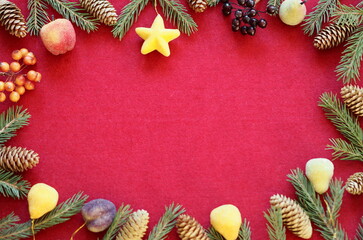 Congratulatory New Year or Christmas background with place for text.Felt red background with laid out fir branches and cones along the edges.