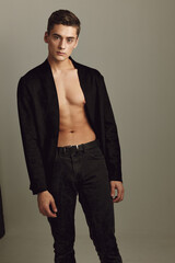 Fototapeta premium A man in a black shirt unbuttoned fashionable hairstyle Studio Model posing