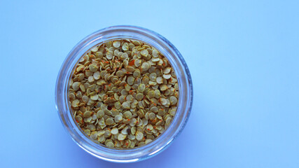Sweet pepper seeds in a glass jar. Dried chili seeds. Place for text. Selective focus.