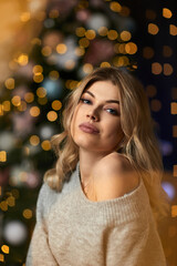 portrait of beautiful young woman with long curly hair on a background with bokeh. Christmas and New Year magic