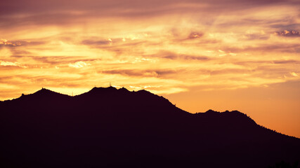 Colorful sunset in East San Francisco Bay Area, with brightly colored clouds covering Mt Diablo summit; Contra Costa County, California