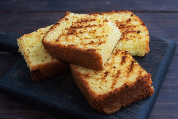 Slices toast wheat bread on a dark wooden background. Close up.