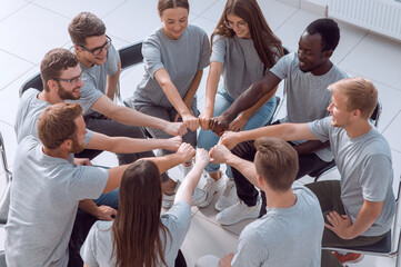 group of young like-minded people making a circle out of their h