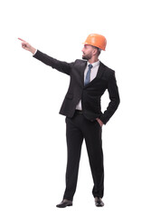 in full growth. young businessman in helmet pointing to copy space