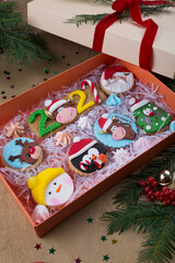 Gift box of Christmas cookies and cupcakes decorated with icing and marzipan. Various colorful new year pastry in Christmas set up, copy space