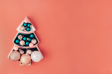 christmas decorations in plate in form of fir tree on orange background, top view with copy space