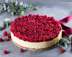 Delicious cheesecake fully covered  with raspberries on light grey background. Beautiful Christmas...
