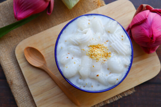 Krong Krang Kati -Thai dessert of boiled flour in coconut milk and topped with sesame close up view served on the wooden tray