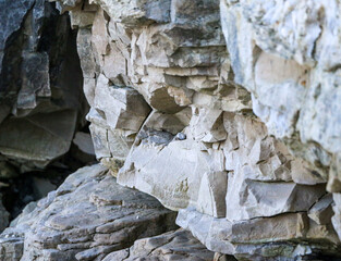mountain textures of stones with interlayers of gypsum, colored quartz, clay, sand and other layers of various ores, with different textures, color and density, in gypsum ore quarry.