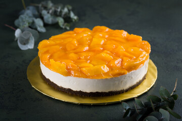 Delicious cheesecake fully covered with mango slices on light grey background. Beautiful Christmas or Valentine dessert, copy space