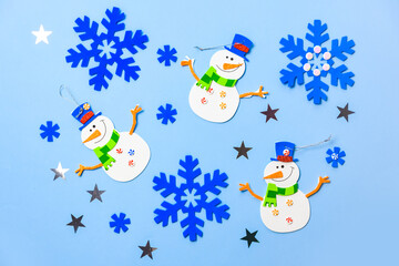 Christmas tree hanging ornaments. Snowman parts on blue background. Christmas crafts ideas. Top view. space for text.