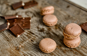 coffee macaroons on a wooden background with dark chocolate. Nice snack for tea. Delicious and cute gift set. Warm flatley made of chocolate and macaroons