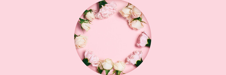 Fototapeta na wymiar Festive greeting web banner with a bouquet of roses lying on a carved background of pink paper.