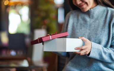 Closeup image of a beautiful young woman opening a gift box