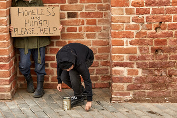 homeless kids beggars on the street with social message on the cardboard, suffer from poverty and loneliness