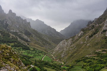 Fototapeta na wymiar landscape of a mountainous valley with fog and dramatic sky, gray sky