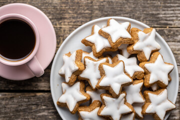 Icing gingerbread stars. Traditional Christmas cookies and coffee cup.