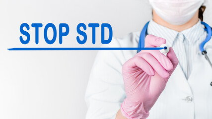 Close up female doctor writing words - STOP STD (Sexually transmitted diseases) with marker. Medical concept