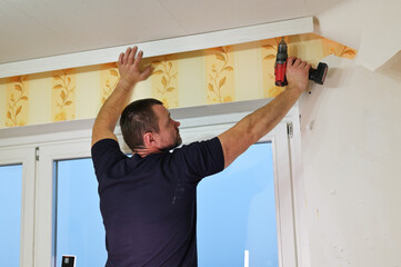 An adult man works with a screwdriver in a room. Home renovation concept.