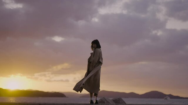 夕暮れの海の街にいる女性