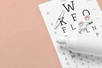 Fototapeta premium Container with contact lenses, tweezers, solution and eye test chart on color background