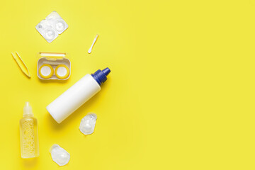 Container with contact lenses, solutions and tweezers on color background