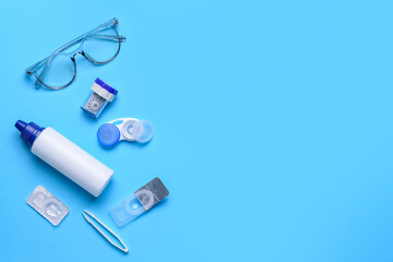 Containers with contact lenses, solution tweezers and eyeglasses on color background