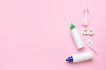 Container with contact lenses, solutions and tweezers on color background