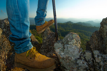 The feet of a traveler resting on a plateau. POV view. Sitting on top of a high hill. Independent concept.