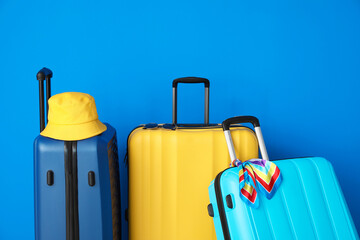 Packed suitcases near color wall