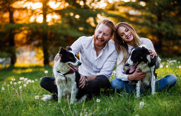 Romantic happy couple in love enjoying their time with pets in nature