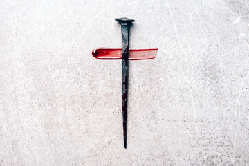 Christian cross made with rusty nails, drops of blood on grey background. Copy space. Good Friday,...