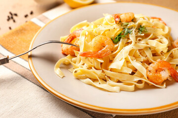 Plate of tasty pasta with shrimps on table