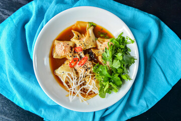 Boiled meat dumplings with fresh parsley, soy sauce and sesame seeds. Delicious meal for dinner.