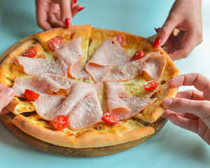 Pizza with bacon, salami and vegetables. Ham and tomatoes pizza with melted cheese.