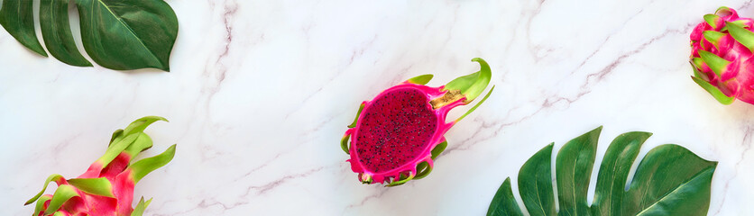 Creative flat layout with fresh organic pink dragon fruit, pitaya or pitahaya, on marble table with...