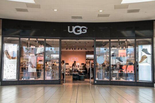 Exterior of Ugg fashion clothing store shop showing company logo, sign, signage and branding.  Inside shopping centre mall