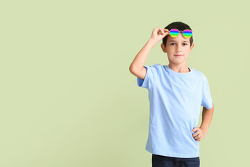 Cute boy wearing stylish sunglasses against color background